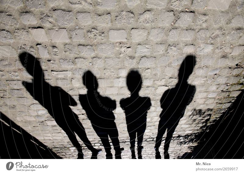 Schattenmänner maskulin 4 Mensch stehen schwarz Schattenspiel Pflastersteine Körperhaltung Mauer Silhouette Schutz Strukturen & Formen Kontrast Licht
