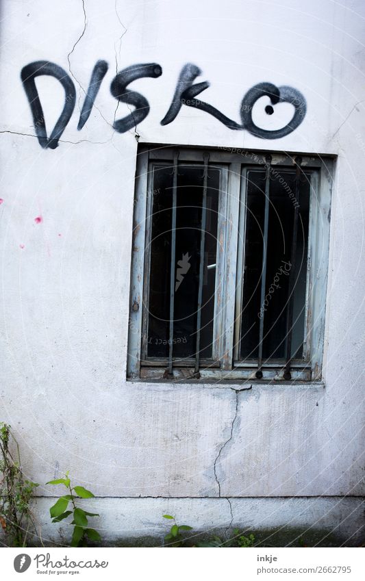 Spelunke Menschenleer Mauer Wand Fassade Fenster Gitter Beton Schriftzeichen Graffiti bedrohlich dunkel hässlich kalt Disco schwarz grau trist Farbfoto