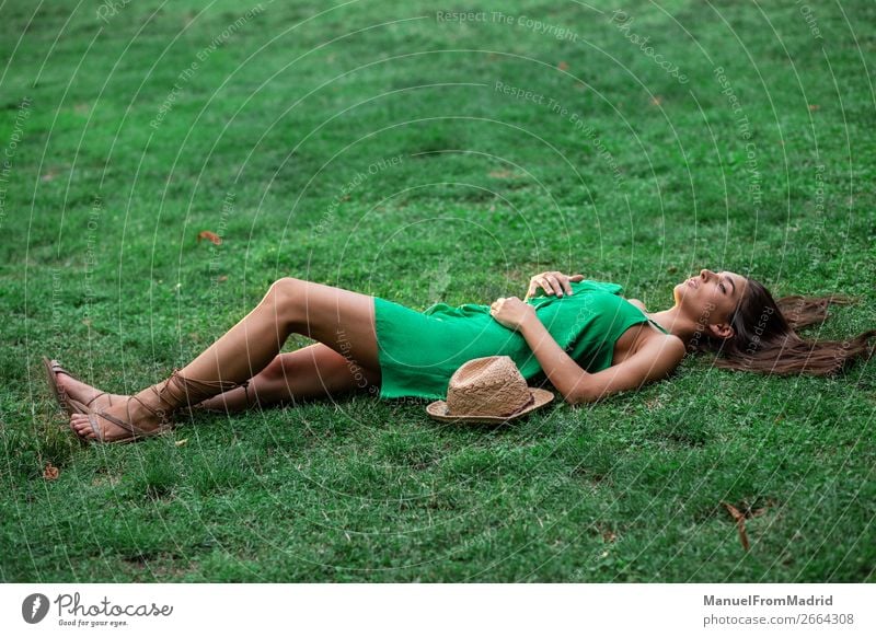 junge, fröhliche Frau, die sich auf das Gras legt. Lifestyle Glück schön Freizeit & Hobby Sommer Mensch Erwachsene Natur Park Wiese Lächeln authentisch
