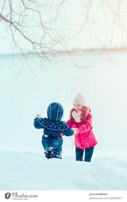 Teenagermädchen genießt Schnee mit ihrer kleinen Schwester Lifestyle Freude Glück Winter Winterurlaub Mensch Kind Kleinkind Mädchen Frau Erwachsene Mutter