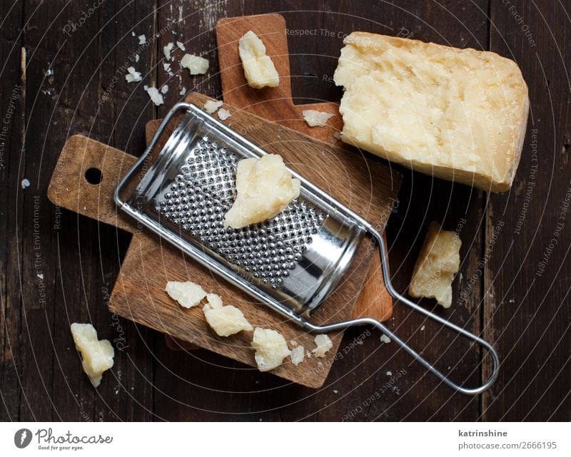 Gereifter Parmesankäse Käse Holz alt dunkel braun gelb parmiggiano geschreddert Textfreiraum Molkerei Lebensmittel Feinschmecker Hartkäse Zutaten Italienisch