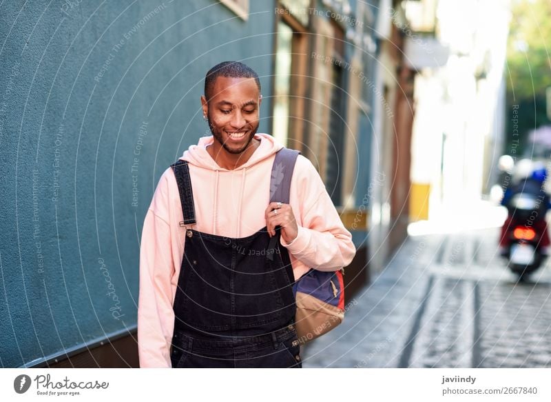 Junger schwarzer Mann, der lächelnd die Straße hinuntergeht. Lifestyle Glück schön Mensch maskulin Junger Mann Jugendliche Erwachsene 1 18-30 Jahre Mode