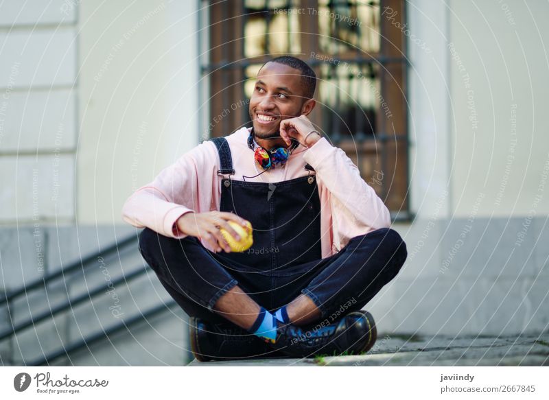 Junger schwarzer Mann isst einen Apfel auf städtischen Stufen sitzend Frucht Essen Lifestyle Glück schön Mensch maskulin Junger Mann Jugendliche Erwachsene 1