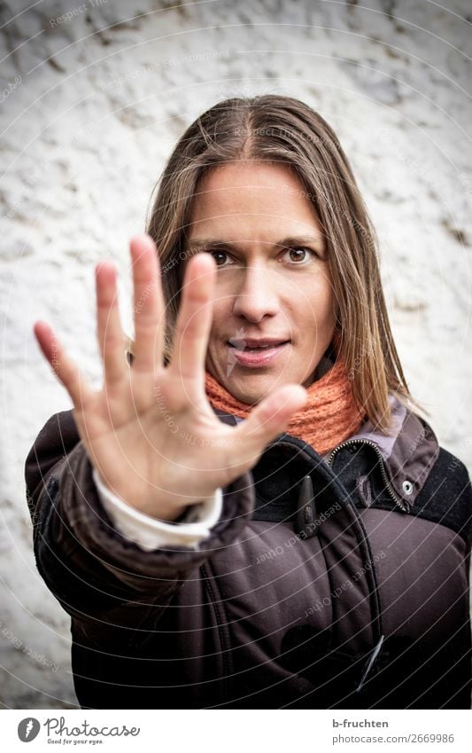 Halt, Stop! Frau Erwachsene Gesicht Hand Finger Herbst Mauer Wand Mantel Schal Bewegung Kommunizieren stehen kalt Angst gefährlich Respekt Misstrauen Sex