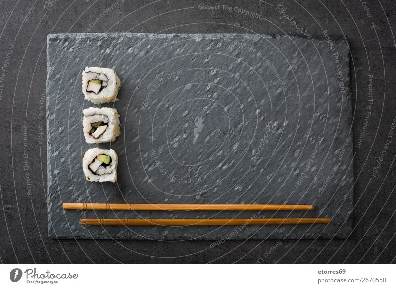 weißes Sushi und Essstäbchen auf schwarzem Schiefer Lebensmittel Gesunde Ernährung Foodfotografie Japanisch Japaner Reis Fisch Lachs Meeresfrüchte Brötchen