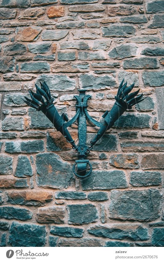 Zwei alte Fackeln, die an einer Steinmauer in einem mittelalterlichen Dorf hängen Design Ferien & Urlaub & Reisen Tourismus Dekoration & Verzierung Kultur Stadt