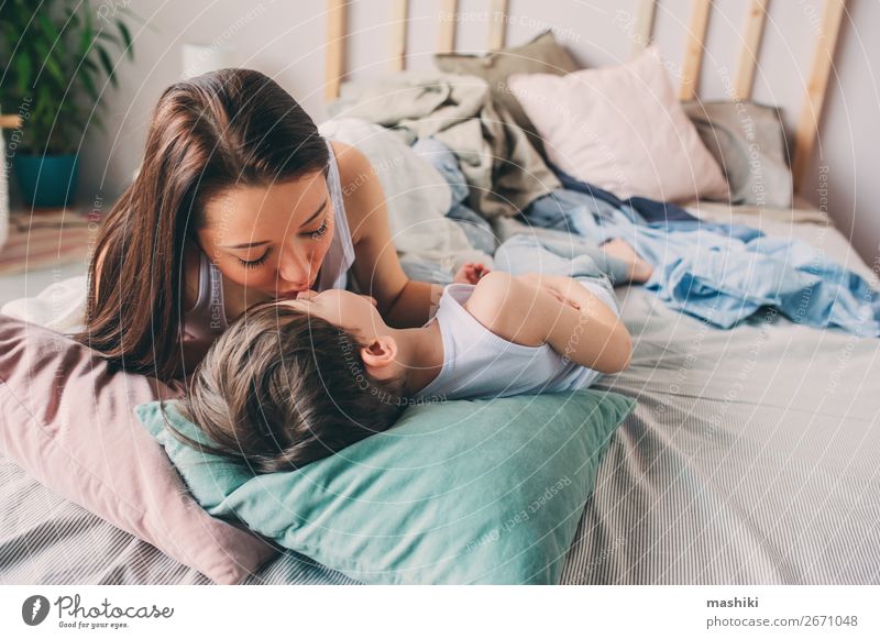 Mutter küsst ihren Kleinkind-Sohn im Bett für eine gute Nacht. Lifestyle Freude Glück Leben Erholung Spielen Schlafzimmer Kind Junge Eltern Erwachsene