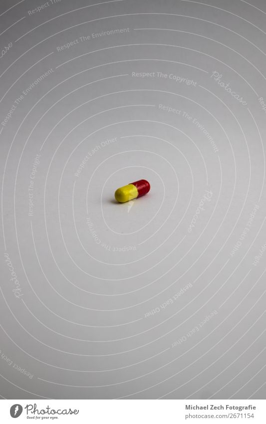 Pille in roter und gelber Farbe auf weißem Hintergrund Schalen & Schüsseln Behandlung Krankheit Medikament Wissenschaften Holz blau rosa Tablette