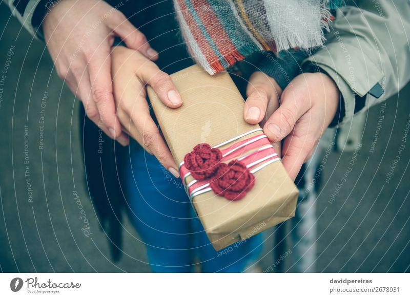 Frauen- und Männerhände mit Geschenkbox im Außenbereich Lifestyle Glück Winter Feste & Feiern Geburtstag Mensch Erwachsene Mann Paar Hand Herbst Blume Straße