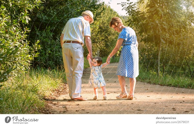 Großeltern und Baby-Enkel laufen auf Naturpfad Lifestyle Glück Sommer Kind Mensch Frau Erwachsene Mann Großvater Großmutter Familie & Verwandtschaft Park Hut