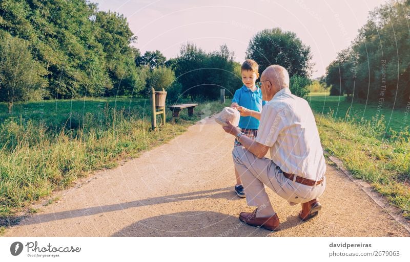 Großvater zeigt seinen Hut dem Enkelkind im Freien. Lifestyle Freude Glück Freizeit & Hobby Spielen Sommer Kind Junge Mann Erwachsene Eltern