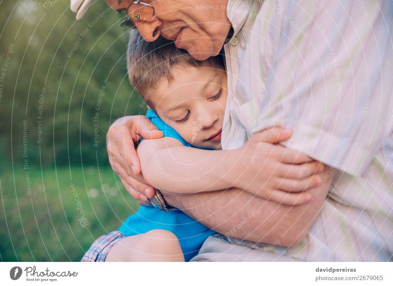Glücklicher Enkel umarmt Großvater vor dem Hintergrund der Natur im Freien Lifestyle Erholung Freizeit & Hobby Sommer Garten Kind Mensch Junge Mann Erwachsene