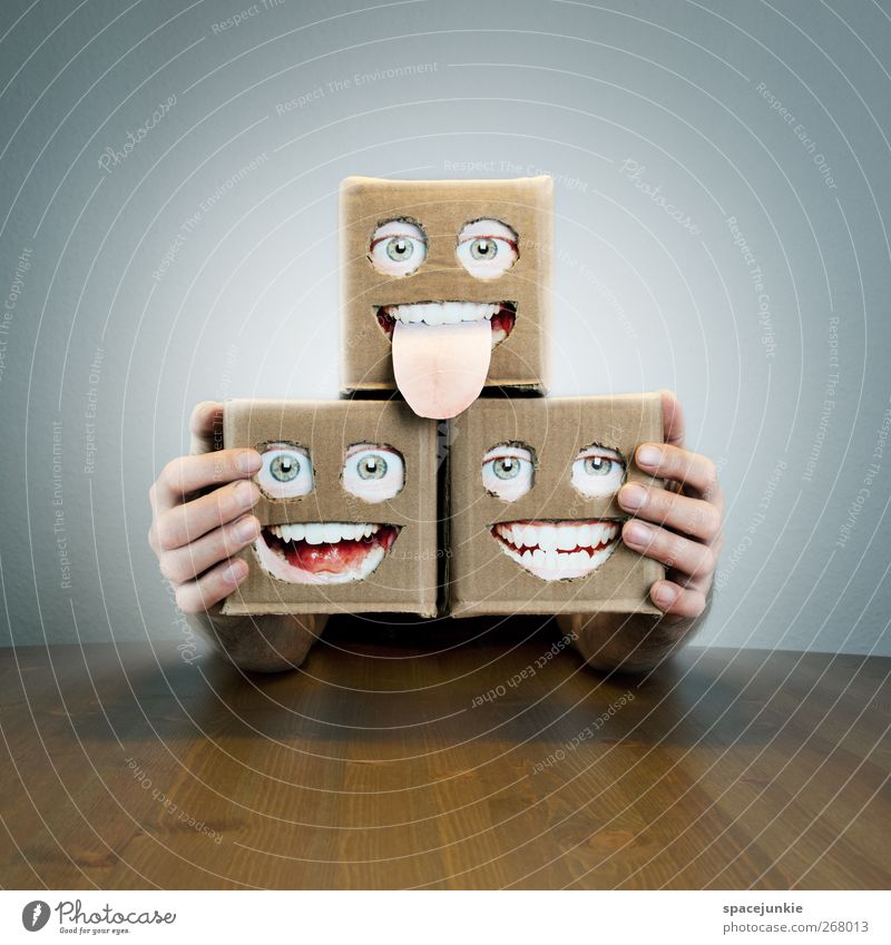 Künstlertrio beobachten Lächeln lachen schreien Blick leuchten außergewöhnlich gruselig klein trashig Karton Gesicht Auge Mund Tisch Roboter 3 verrückt surreal