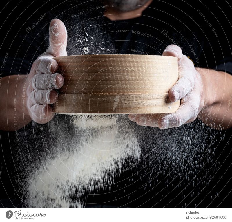 Mann siebt weißes Weizenmehl durch ein Holzsieb. Teigwaren Backwaren Brot Ernährung Küche Koch Mensch Erwachsene Hand Sieb Bewegung machen frisch schwarz Mehl