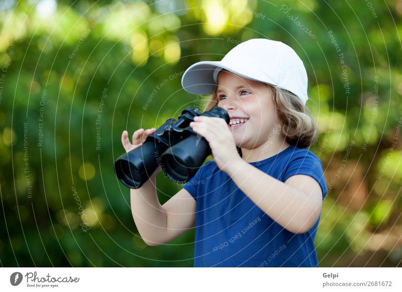 Kleines süßes Mädchen im Park, das mit einem Fernglas aussieht. Freude Glück schön Gesicht Leben Freizeit & Hobby Ferien & Urlaub & Reisen Camping Sommer Kind
