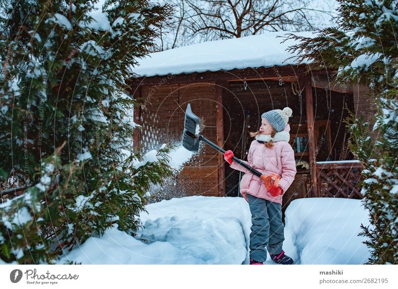 Kind Mädchen hilft, den Weg vom Schnee zu reinigen mit Schaufel Spielen Winter Haus Garten Werkzeug Wetter Unwetter Schneefall Fröhlichkeit Sauberkeit kalt