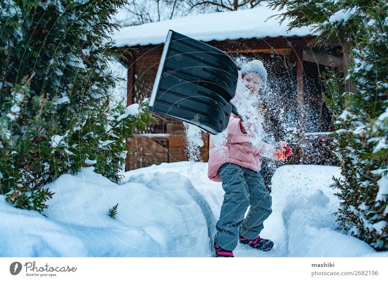 Kind Mädchen, das hilft, den Weg mit einer Schaufel vom Schnee zu reinigen. Spielen Winter Haus Garten Werkzeug Wetter Unwetter Schneefall Fröhlichkeit