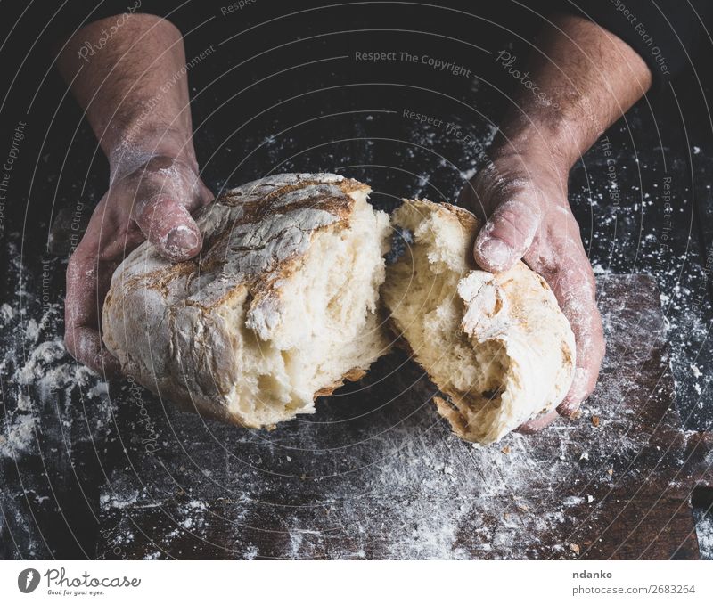gebrochenes Weißbrot in männlichen Händen Brot Ernährung Tisch Küche Koch Mensch Hand Finger Holz machen dunkel frisch braun schwarz weiß Tradition backen