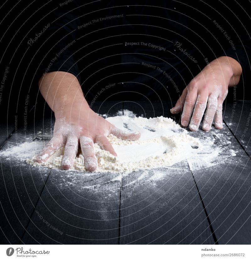 weißes Weizenmehl auf einem schwarzen Holztisch Teigwaren Backwaren Brot Tisch Küche Koch Mensch Mann Erwachsene Hand machen dunkel frisch kneten Bäcker