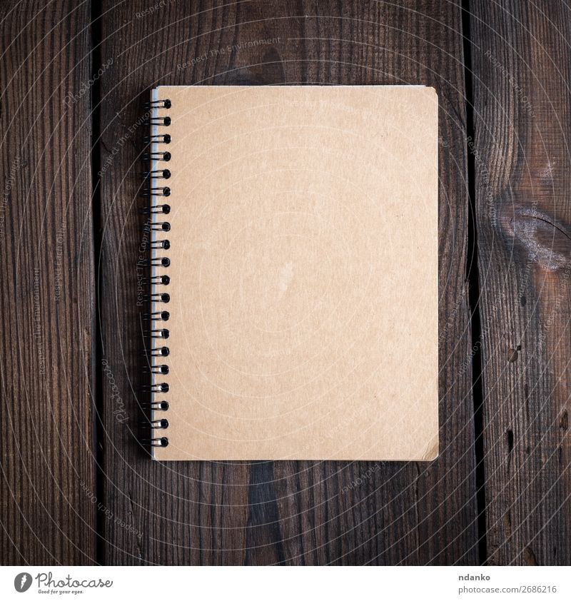 Notizbuch auf einer schwarzen Eisenfeder mit braunen Blättern Schule Business Buch Papier Holz Idee Hintergrund blanko Entwurf Textfreiraum Tagebuch Bildung