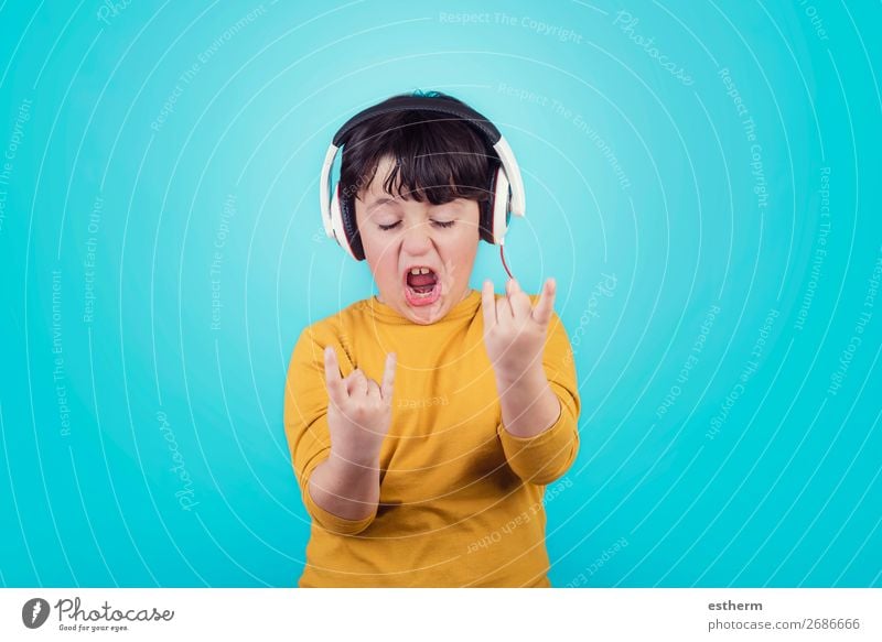 Junge mit Kopfhörern zeigt Rock Seufzer auf blauem Hintergrund Lifestyle Freude Entertainment Musik Mensch maskulin Kind Kindheit 1 8-13 Jahre Musik hören