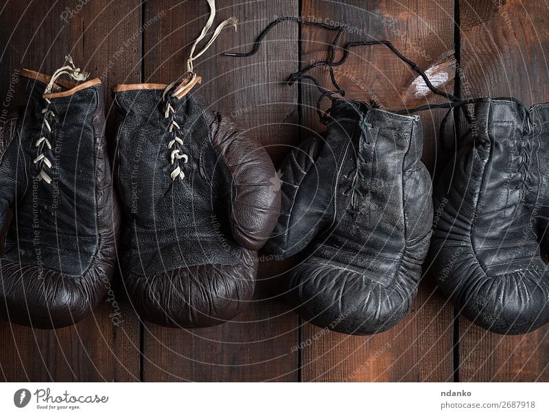 zwei Paar alte Boxhandschuhe aus Leder Sport Accessoire Handschuhe Holz Fitness dunkel retro braun schwarz Schutz Konkurrenz Aktion antik Antiquität Hintergrund
