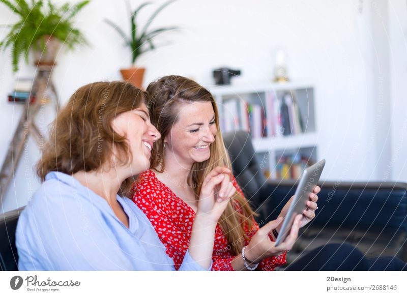 Frauen zu Hause sitzen auf dem Sofa und benutzen einen Tablet-PC. Lifestyle Freude Glück schön Erholung Wohnung sprechen Computer Technik & Technologie Internet