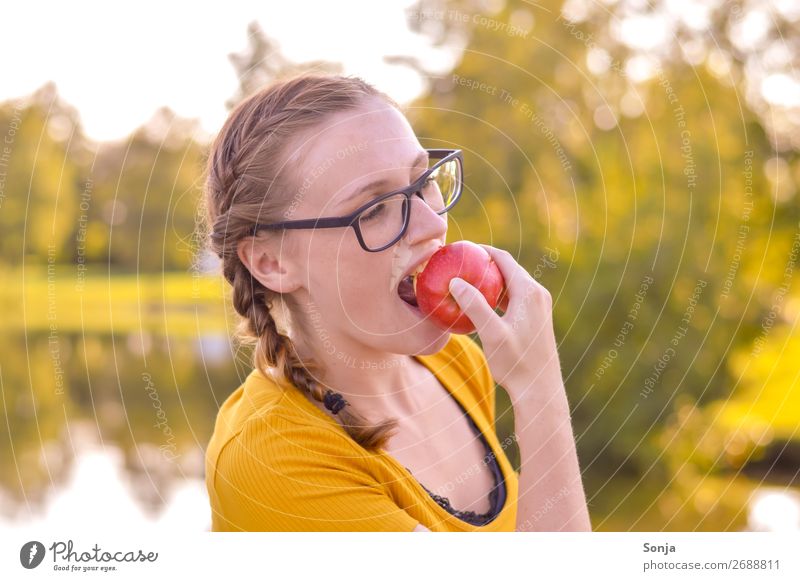 Junge Frau beißt in einen Apfel Lebensmittel Essen Lifestyle Freude Gesundheit Gesunde Ernährung Wohlgefühl Sommer feminin Jugendliche 1 Mensch 13-18 Jahre