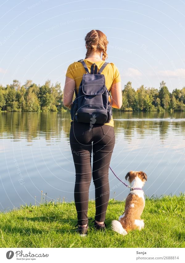 Junge Frau mit kleinen Hund am See Lifestyle Sommer wandern Mensch feminin Jugendliche 1 18-30 Jahre Erwachsene T-Shirt Jeanshose Zopf Tier Rucksack beobachten