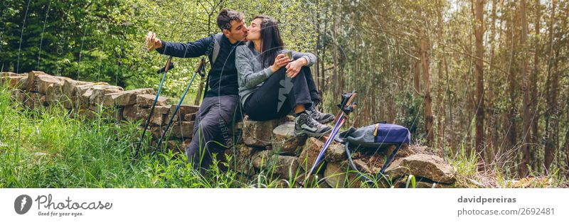 Ein Paar küsst sich, während man eine Pause macht, um Trekking zu machen. Essen trinken Lifestyle Freizeit & Hobby Abenteuer Berge u. Gebirge wandern Sport