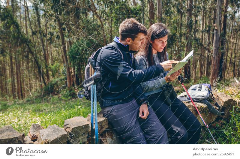 Ein Paar beim Trekking, das auf eine Karte schaut. Freizeit & Hobby Ausflug Abenteuer Sightseeing Berge u. Gebirge wandern Sport Mensch Frau Erwachsene Mann