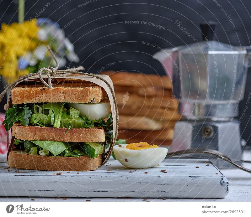 Sandwich aus French Toast und Salatblättern und gekochtem Ei Fleisch Gemüse Brot Frühstück Mittagessen Abendessen Vegetarische Ernährung Fastfood Tisch Holz