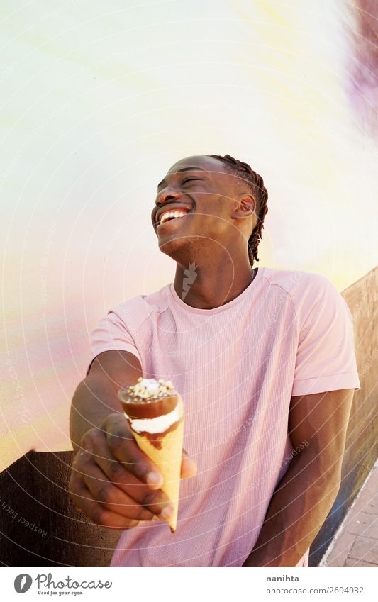 Junger, gutaussehender schwarzer Mann hält einen Eisbecher. Lebensmittel Speiseeis Stil Glück Sommer Sonnenbad Mensch maskulin Junger Mann Jugendliche