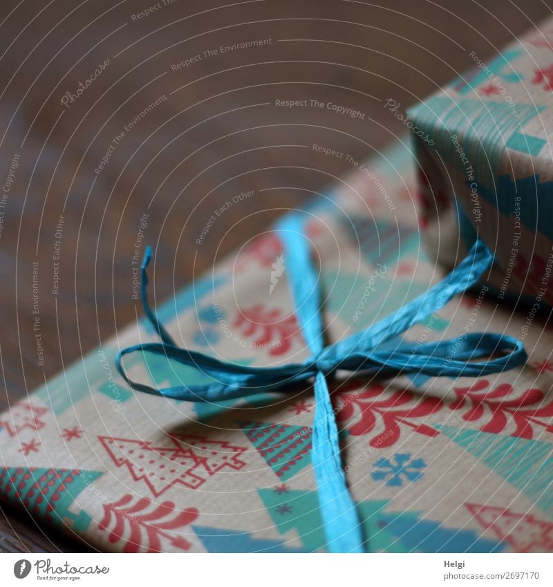 Detailaufnahme eines verpackten Geschenks in Weihnachtspapier mit Band und Schleife aus Bast Feste & Feiern Weihnachten & Advent Dekoration & Verzierung