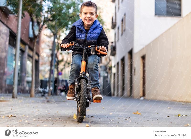 Kleines Kind fährt mit dem Fahrrad auf der Stadtstraße. Lifestyle Freude Glück schön Gesicht Erholung Freizeit & Hobby Spielen Kinderspiel Sommer Sonne Sport