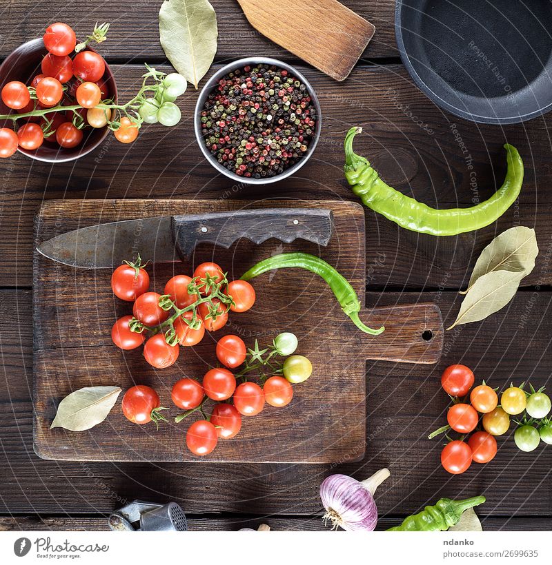reife rote Kirschtomaten auf einem braunen Holztisch Gemüse Kräuter & Gewürze Vegetarische Ernährung Topf Pfanne Messer Sommer Küche frisch klein natürlich oben