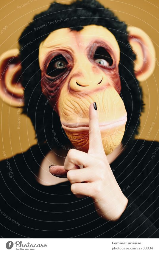 Person with monkey mask making psst gesture 1 Mensch Tier Freude gestikulieren ruhig stumm Verbote Fell Maske Affen Schimpansen Evolution Karneval