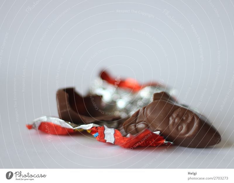 angeknabberter Schokoladenweihnachtsmann liegt auf dem Stanniolpapier Süßwaren Weihnachten & Advent Dekoration & Verzierung Verpackung Folie liegen authentisch