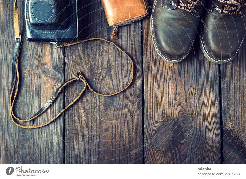 Paar lederne braune Schuhe und eine alte Vintage-Kamera. Stil Design Fotokamera Mode Bekleidung Leder Accessoire Holz retro schwarz Idee Hintergrund lässig