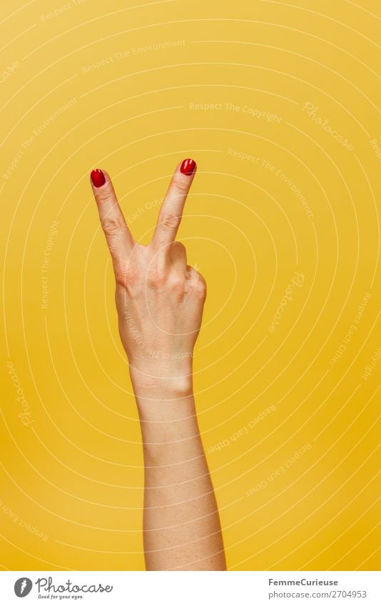 Hand signal for peace against a yellow background feminin 1 Mensch Kommunizieren Frieden gestikulieren Finger Unterarm gelb Nagellack rot Symbole & Metaphern
