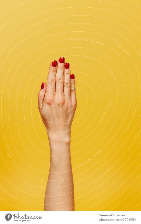 Forearm and hand of a woman in front of a yellow background feminin Junge Frau Jugendliche Erwachsene 1 Mensch 18-30 Jahre 30-45 Jahre gelb rot Nagellack