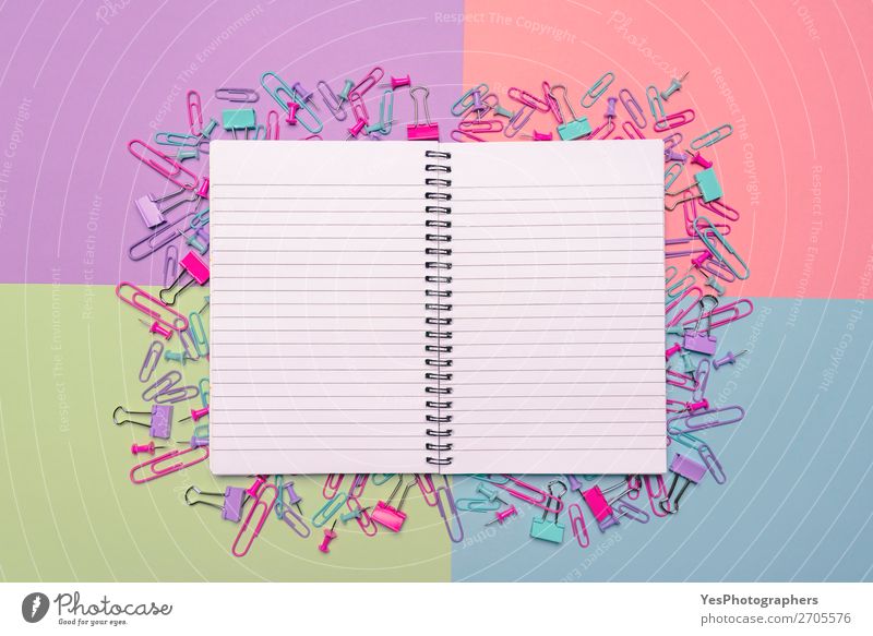 Offenes Notebook und bunte Büroartikel auf dem Schreibtisch Freude Beruf Arbeitsplatz Business Karriere Papier Fröhlichkeit blau grün rosa Farbe obere Ansicht