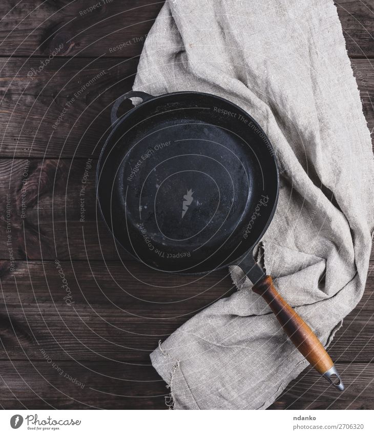 leere schwarze runde Bratpfanne mit Holzgriff Abendessen Pfanne Tisch Küche Metall alt dunkel oben Sauberkeit braun altehrwürdig Hintergrund Holzplatte gießen