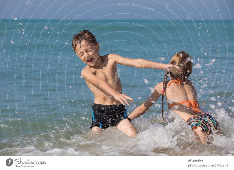Glückliche Kinder, die tagsüber am Strand spielen. Zwei Kinder, die sich im Freien vergnügen. Konzept der Sommerferien und einer freundlichen Familie. Lifestyle