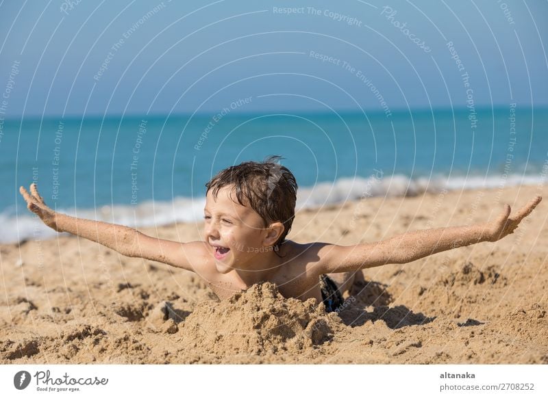 Ein glücklicher kleiner Junge, der tagsüber am Strand spielt. Ein Kind, das Spaß im Freien hat. Konzept des Urlaubs. Lifestyle Freude Glück schön Erholung