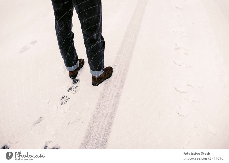 Stehende Person auf verschneiter Straße Schnee Winter Asphalt Spur Beine stehen Mensch Natur kalt Landschaft weiß Jahreszeiten Frost Tag gefroren Ausflug