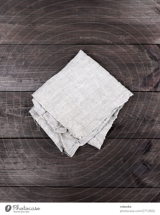 gefaltetes graues Handtuch auf braunem Holzgrund Design Tisch Küche Stoff retro Sauberkeit Serviette Hintergrund Tischwäsche Leinen Konsistenz Baumwolle Raum