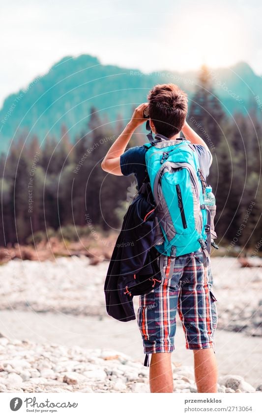 Junger Wanderer mit Rucksack schaut durch ein Fernglas. Lifestyle Leben Freizeit & Hobby Ferien & Urlaub & Reisen Tourismus Ausflug Sommer Berge u. Gebirge