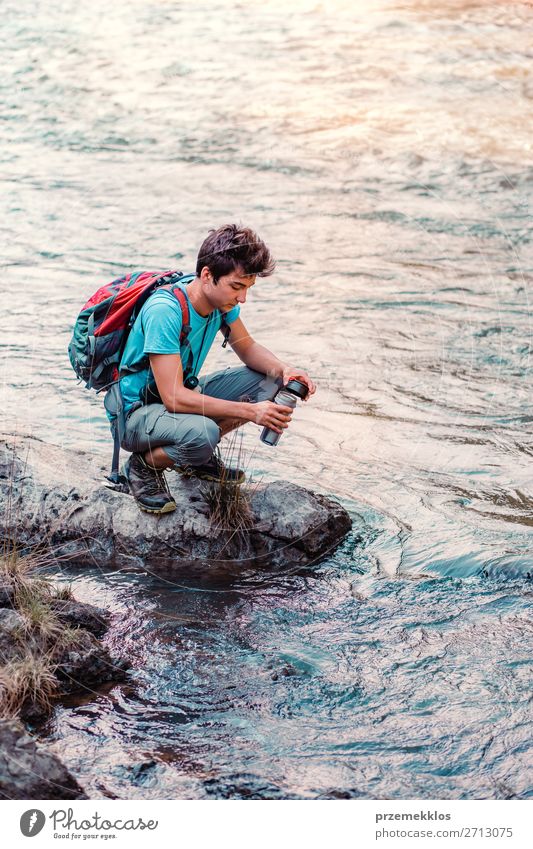 Ein junger Wanderer holt sich reines Wasser aus einem Fluss. Körper Leben Ferien & Urlaub & Reisen Tourismus Ausflug Abenteuer Sommer wandern Mensch Junge