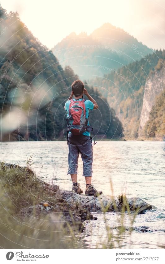 Junger Tourist mit Rucksack schaut durch ein Fernglas. Lifestyle Leben Freizeit & Hobby Ferien & Urlaub & Reisen Tourismus Ausflug Sommer Sommerurlaub